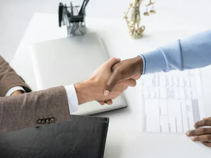 Business handshake close up over paperwork on a tidy desk, symbolizing trusted services on Local Directory Bridge